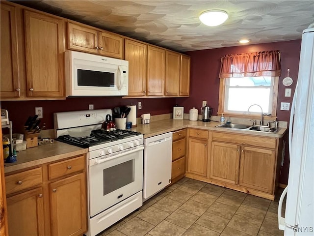 kitchen featuring white appliances, sink, and light tile patterned floors