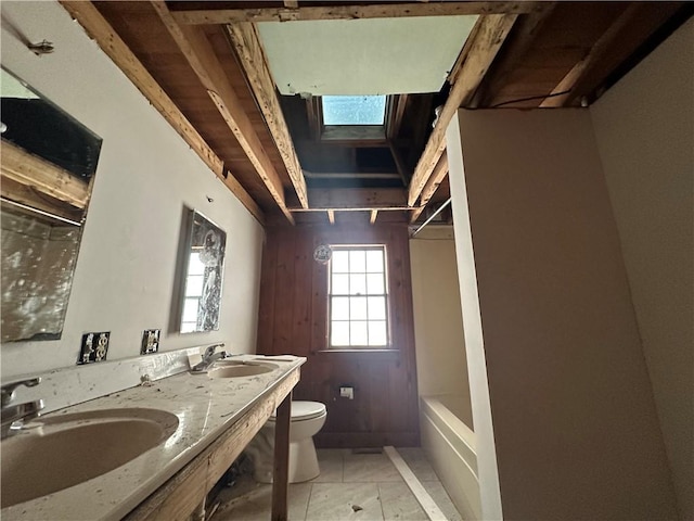 bathroom with toilet, tile patterned flooring, a skylight, and vanity