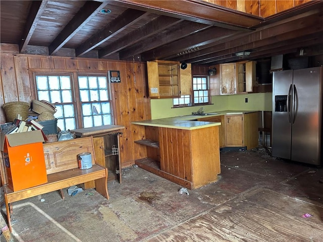 interior space with sink, stainless steel fridge, and wood walls