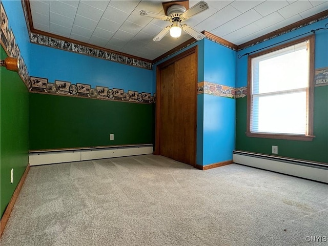 unfurnished bedroom with carpet flooring, ceiling fan, crown molding, and a baseboard radiator