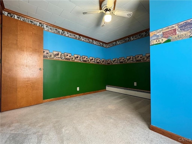 carpeted spare room with ceiling fan, ornamental molding, and baseboard heating