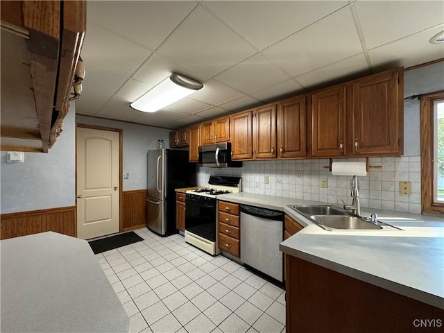 kitchen featuring appliances with stainless steel finishes, a paneled ceiling, light tile patterned floors, and sink