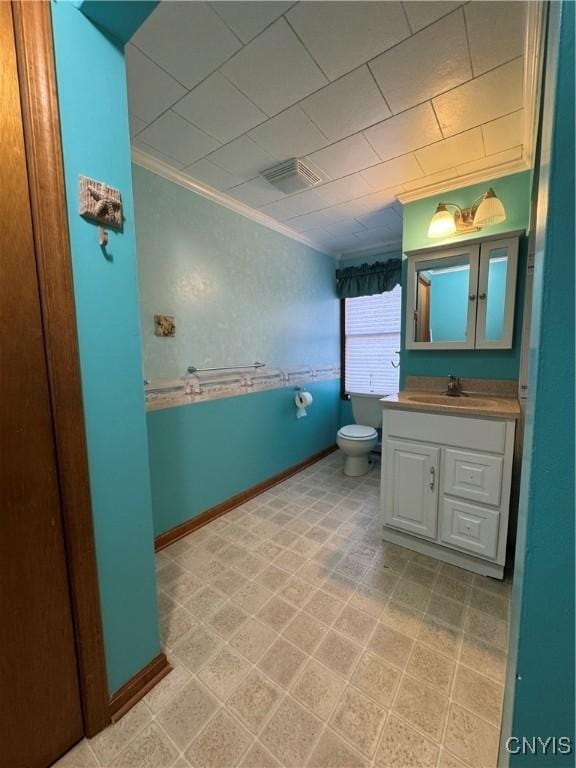 bathroom with crown molding, vanity, and toilet