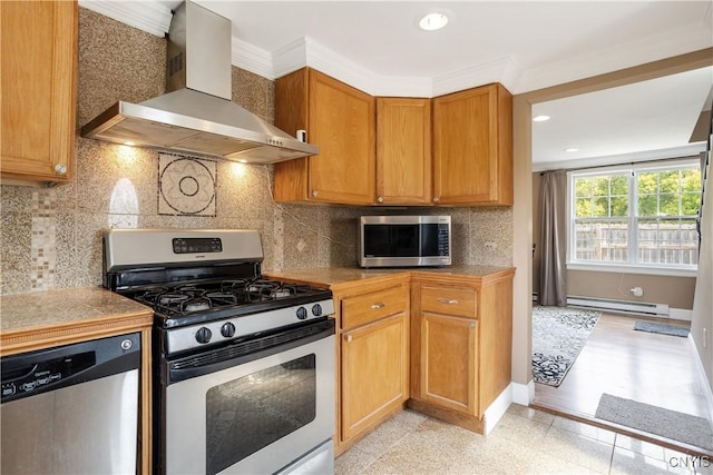 kitchen featuring a baseboard radiator, stainless steel appliances, wall chimney range hood, decorative backsplash, and ornamental molding