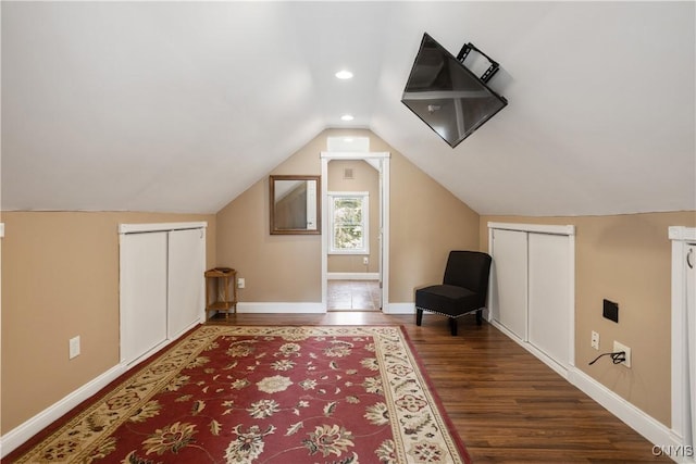 additional living space with dark wood-type flooring and vaulted ceiling