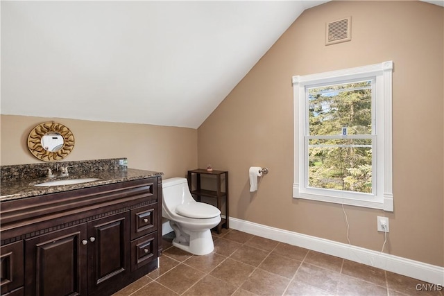 bathroom featuring vanity, vaulted ceiling, and toilet