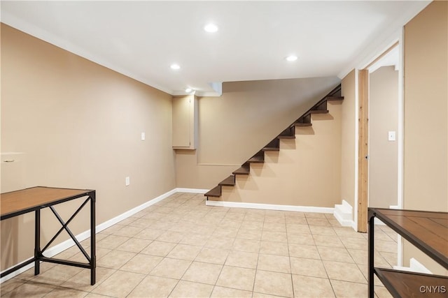 basement featuring light tile patterned flooring and ornamental molding