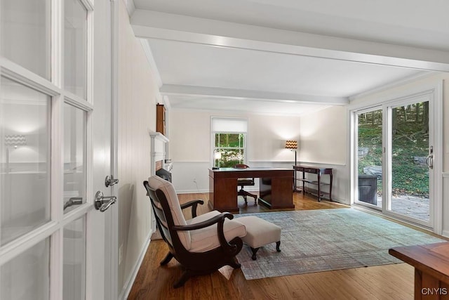 sitting room with beamed ceiling, wood-type flooring, and ornamental molding