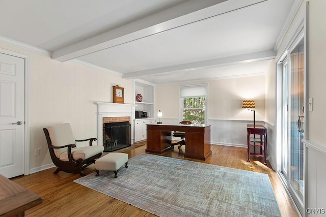 sitting room with beam ceiling, built in shelves, light hardwood / wood-style flooring, and a fireplace