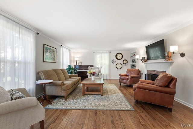 living room with a fireplace, hardwood / wood-style flooring, and ornamental molding