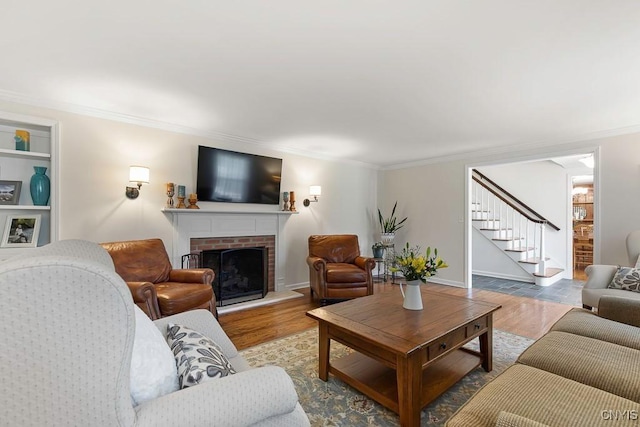 living room with a fireplace, hardwood / wood-style flooring, and crown molding