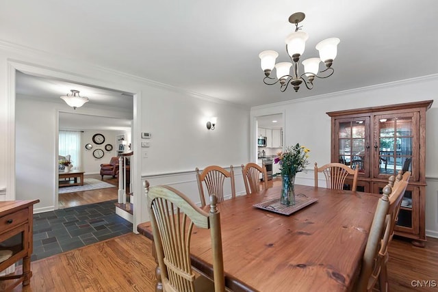 dining area with a chandelier and crown molding