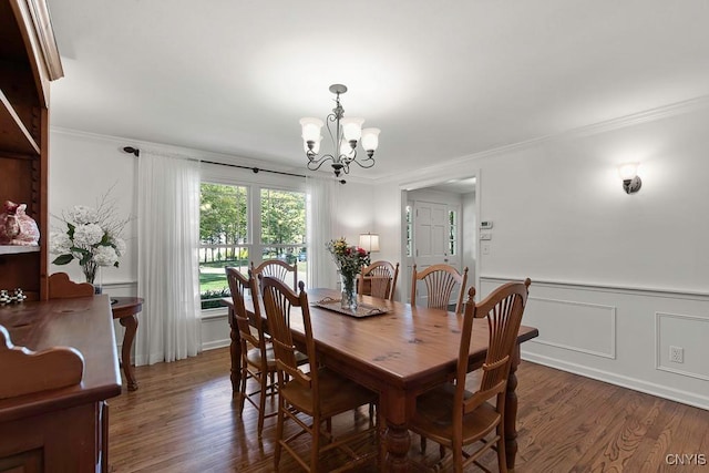 dining room with dark hardwood / wood-style floors, ornamental molding, and a chandelier