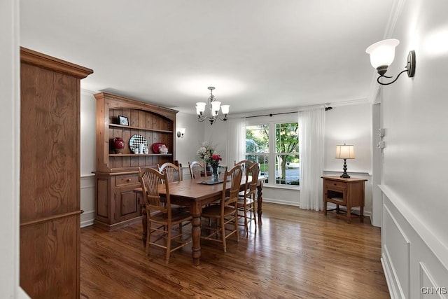 dining area with dark hardwood / wood-style flooring, crown molding, and an inviting chandelier