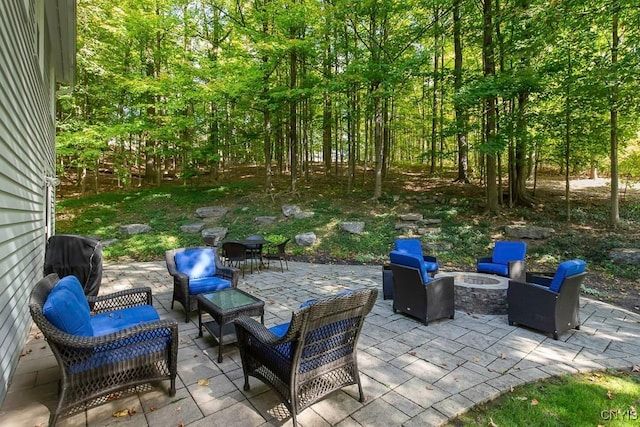 view of patio with a grill and an outdoor living space with a fire pit