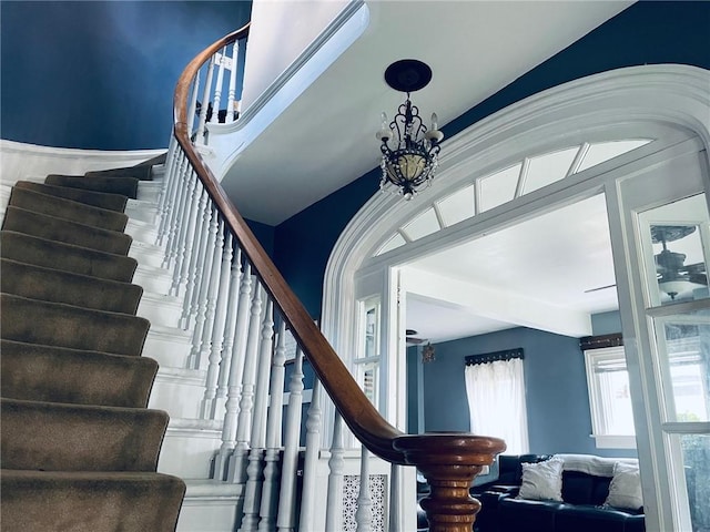 stairs with a chandelier