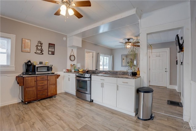 kitchen featuring ornamental molding, white cabinets, light wood-type flooring, and appliances with stainless steel finishes