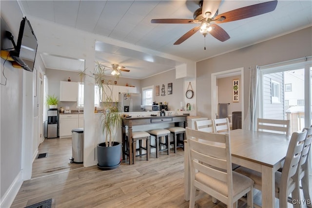 dining area featuring ceiling fan, ornamental molding, and light hardwood / wood-style flooring