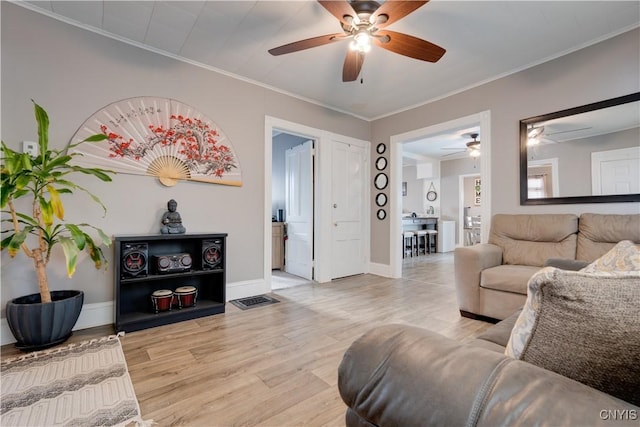 living room with ornamental molding and light hardwood / wood-style flooring