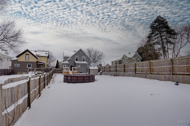 snowy yard featuring a storage shed