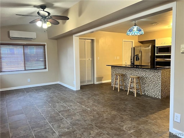 kitchen with ceiling fan, white cabinetry, stainless steel appliances, a kitchen breakfast bar, and a wall unit AC