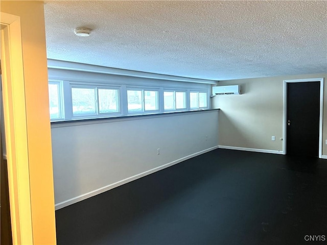 basement featuring a textured ceiling and a wall mounted AC