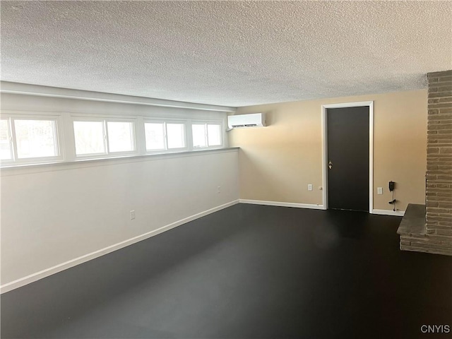 basement with a textured ceiling and a wall unit AC