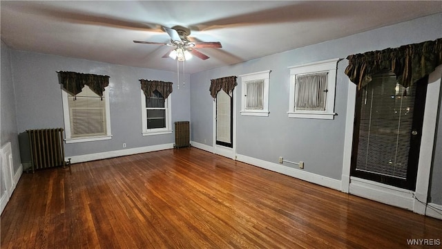 empty room with ceiling fan, radiator heating unit, and hardwood / wood-style floors