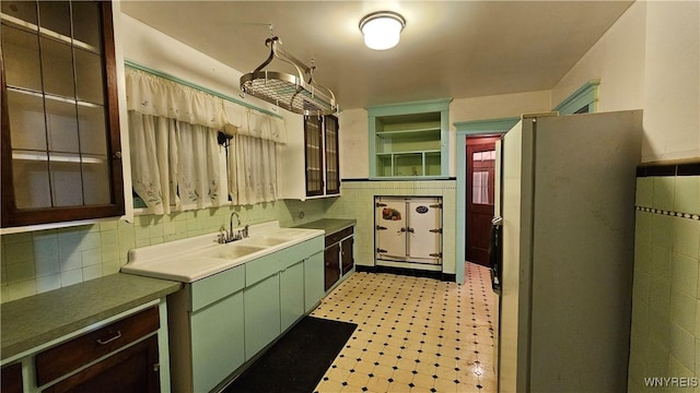 kitchen featuring decorative backsplash, sink, and refrigerator