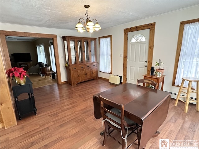 dining space with hardwood / wood-style flooring, a textured ceiling, and a chandelier