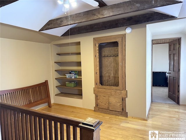 stairway with built in shelves, vaulted ceiling with beams, ceiling fan, and hardwood / wood-style floors