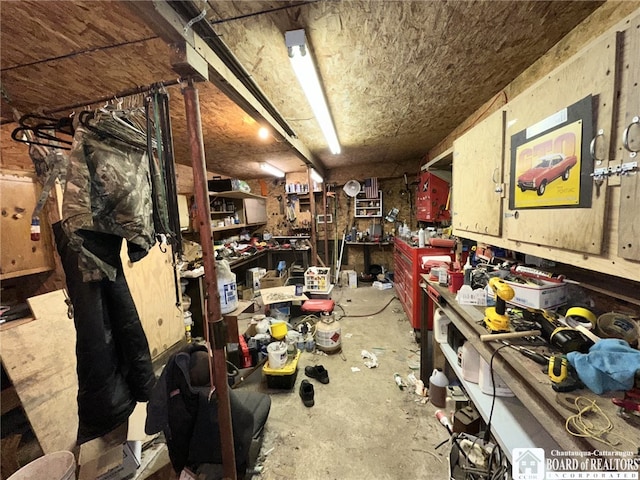 miscellaneous room featuring a workshop area and concrete floors