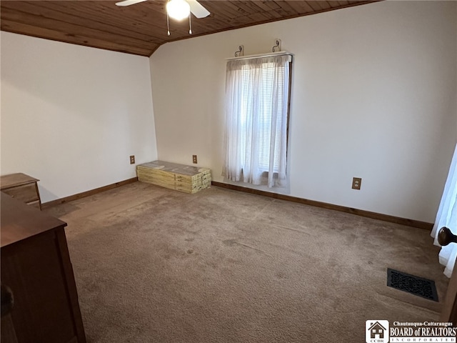 carpeted empty room featuring ceiling fan and wood ceiling