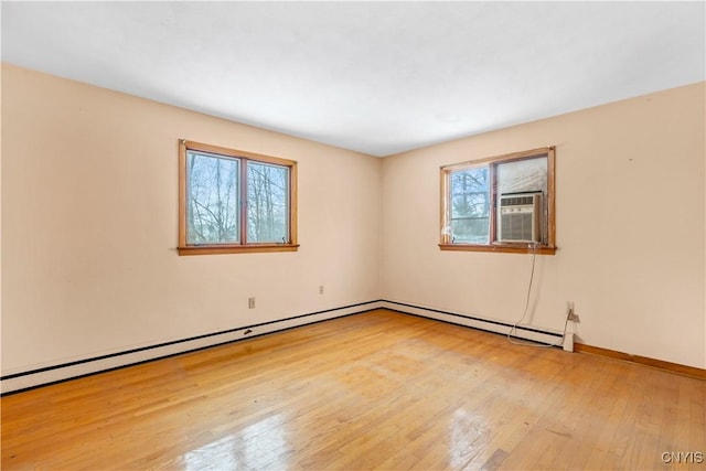 empty room with a wealth of natural light and light hardwood / wood-style flooring