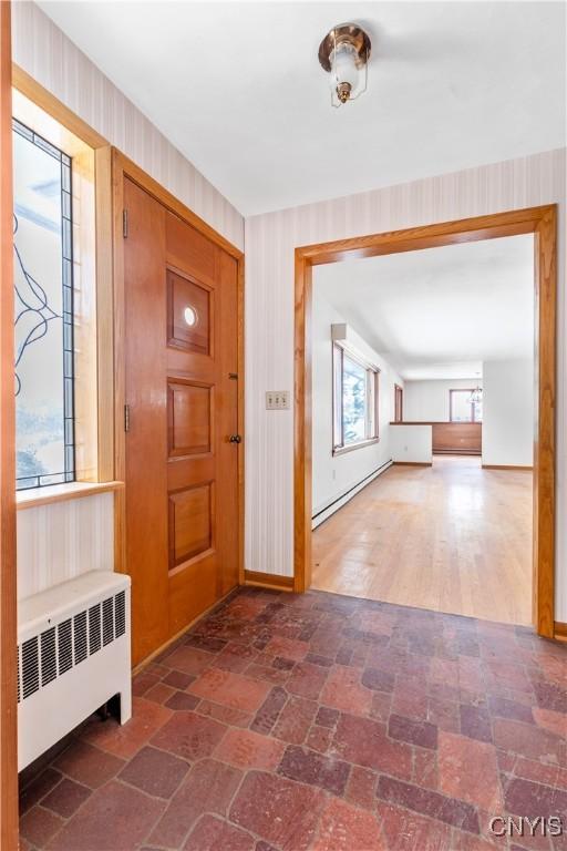 foyer entrance with baseboard heating and radiator