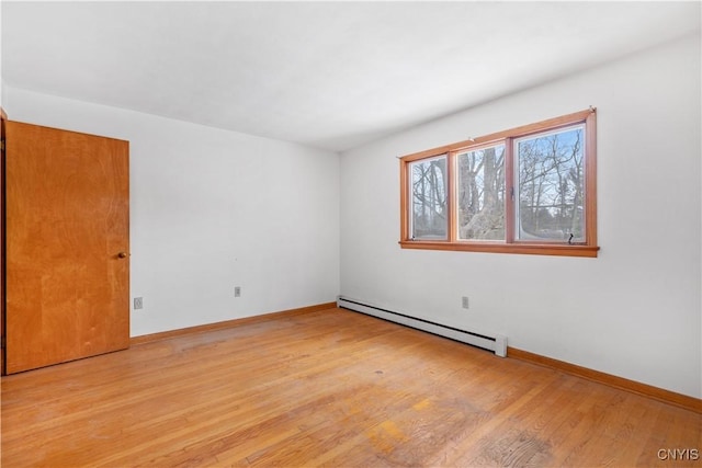 spare room featuring light hardwood / wood-style flooring and a baseboard heating unit