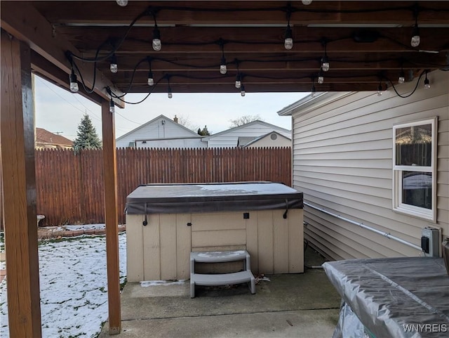 snow covered patio featuring a hot tub