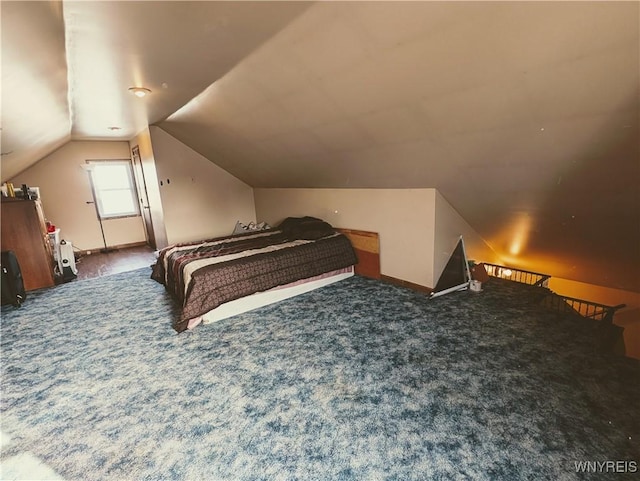 bedroom featuring lofted ceiling and dark colored carpet