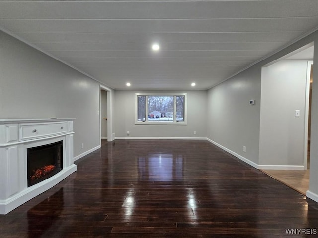 unfurnished living room featuring crown molding and dark hardwood / wood-style flooring