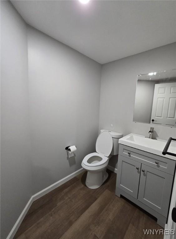 bathroom with hardwood / wood-style floors, vanity, and toilet