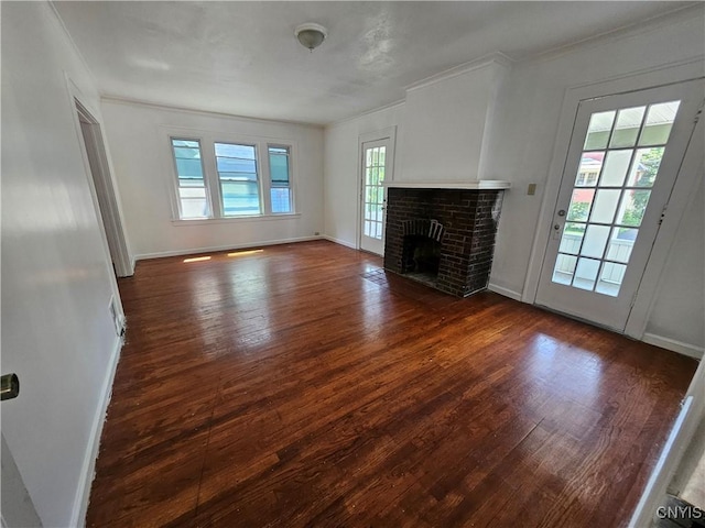 unfurnished living room featuring dark hardwood / wood-style flooring, a brick fireplace, and ornamental molding