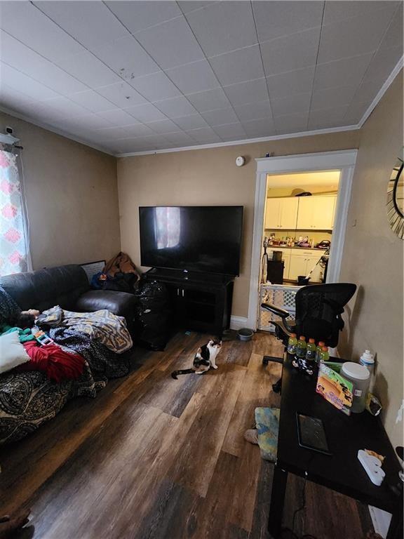 living room with hardwood / wood-style flooring and crown molding