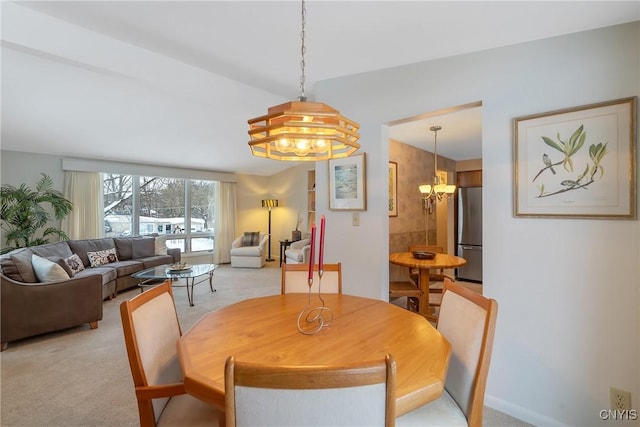 carpeted dining area featuring an inviting chandelier