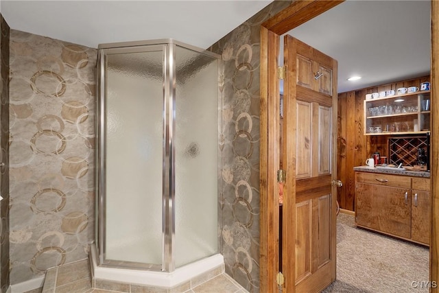 bathroom with vanity, wood walls, and an enclosed shower