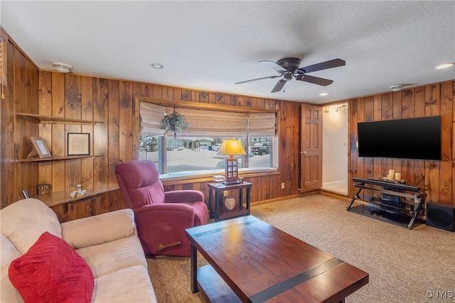 living room with a textured ceiling, light colored carpet, and ceiling fan