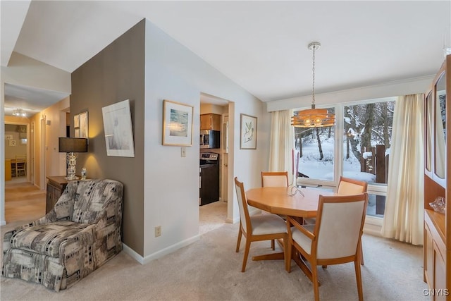 dining space featuring light carpet and lofted ceiling