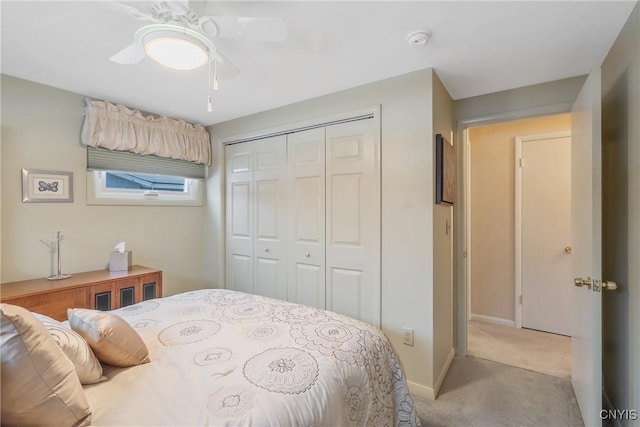 carpeted bedroom with ceiling fan and a closet