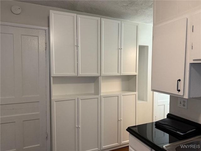 kitchen featuring white cabinetry and a textured ceiling