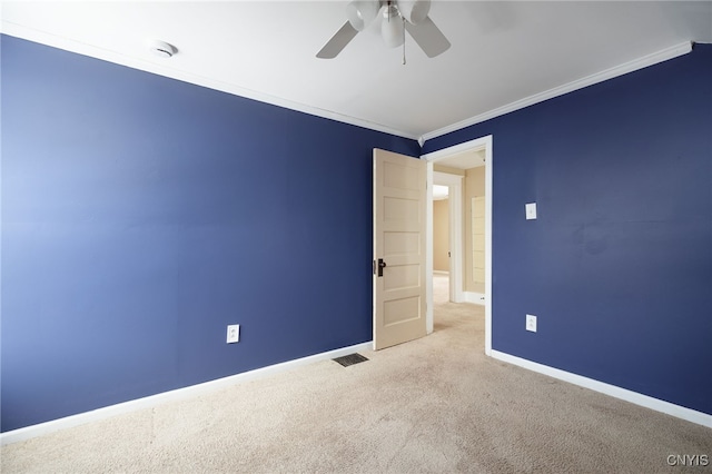 carpeted empty room featuring ceiling fan and ornamental molding