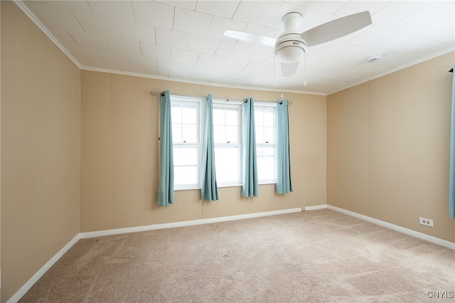 spare room featuring ceiling fan, crown molding, and carpet